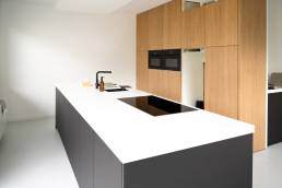 Moderne keuken met wit tafelblad en witte gietvloer