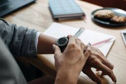 Vrouw kijkt op horloge om tijdswinst aan te duiden